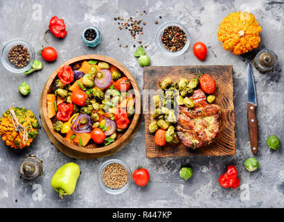 Juicy steak medium rare beef on wooden kitchen board.Grilled meat with Brussels sprouts.BBQ Stock Photo