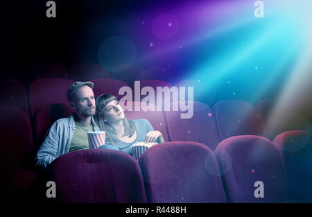 Teenager couple cuddling and watching the climax part of the movie Stock Photo