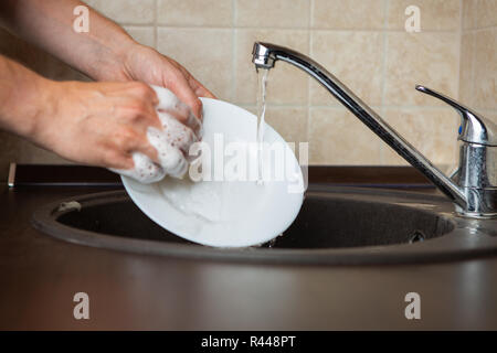 Image of side of man washing white plates Stock Photo