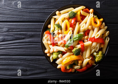 Penne pasta with chickpeas, broccoli, bell pepper and spices close-up in a plate on the table. horizontal top view from above Stock Photo