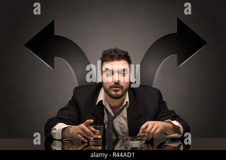 Drunk disappointed man sitting at table with arrows around  Stock Photo