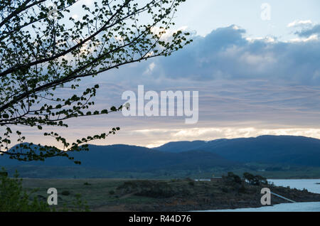 Soft Fluffy clouds near sunset over Lake Jindabyne and the mountains Stock Photo