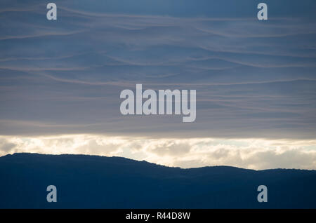 Soft Fluffy clouds near sunset over Lake Jindabyne and the mountains Stock Photo