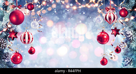 Christmas - Red Baubles Hanging With Fir Branches In Shiny Background Stock Photo