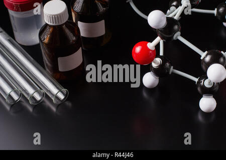 molecular formula and laboratory equipment on dark background. Science organic chemistry concept Stock Photo