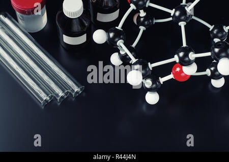 molecular formula and laboratory equipment on dark background. Science organic chemistry concept Stock Photo