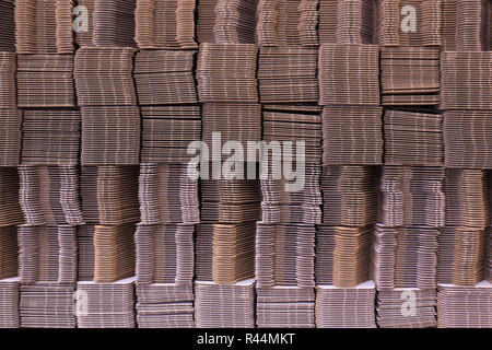 Corrugate cardboard tied with white plastic rope. Corrugated paper single wall. Corrugated fiberboard. Linerboard board. Stack of cardboard boxes. Ple Stock Photo