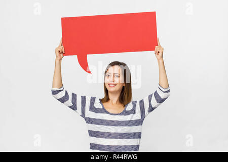 Happy brunette woman in casual clothes with red speech bubble on white background Stock Photo