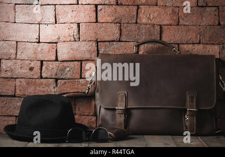 vintage leather bag with sunglasses and hat on wood table, accessories hipster style, prepare for Travel concept and vintage tone Stock Photo