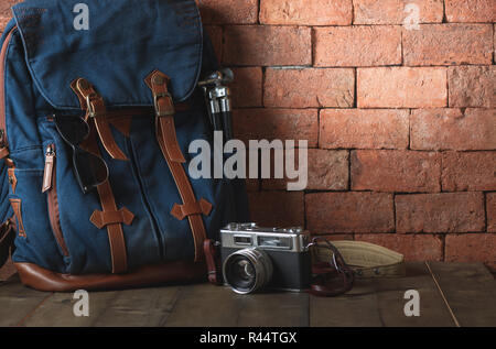 Old vintage canvas bag with vintage camera and hot on wood table, accessories hipster style, Travel concept Stock Photo