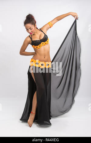 Young girl mulatto dancing in a long black dress candid Stock Photo