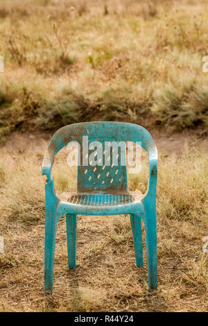 Grungy Retro Damaged Plastic Green Chair Abandoned in a Field Stock Photo