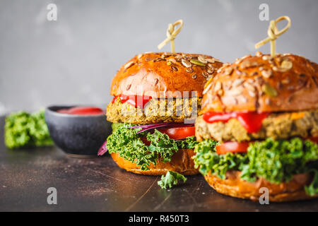 Vegan lentil burgers with kale and tomato sauce on a dark background. Plant based diet cincept. Stock Photo