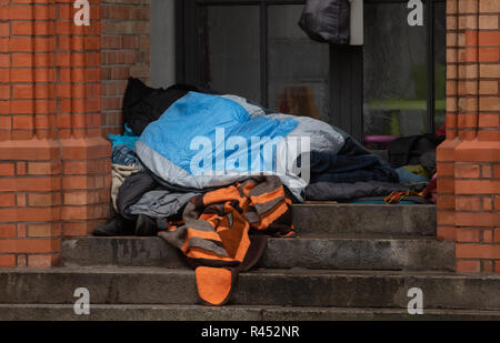 Berlin, Germany. 25th Nov, 2018. A homeless person lies under a blanket in the entrance of a church in Kreuzberg. Credit: Paul Zinken/dpa/Alamy Live News Stock Photo