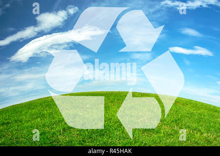 Composite image of an environmental conservation - recycle sign on a green meadow and blue sky earth horizon Stock Photo