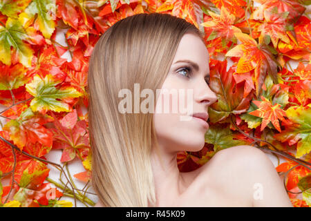 Beautiful young woman lying on leafs Stock Photo