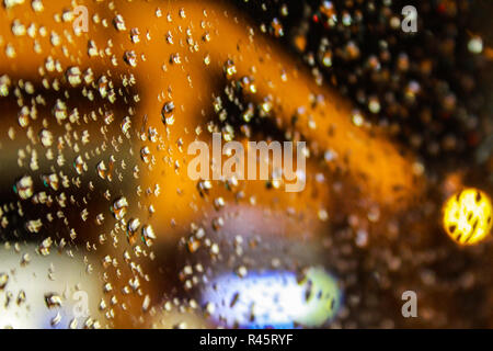 water drops on a transparent glass surface with blurred bokeh background Stock Photo