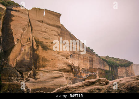 high rock formations at Tunnel Beach during early morning hours, near Dunedin, Otago, South Island, New Zealand Stock Photo