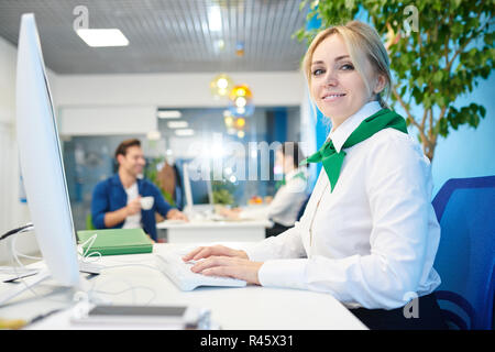 Beautiful young lady working in bank Stock Photo