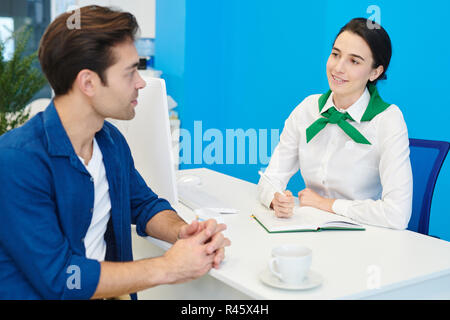 Smiling lady consultant communicating with client Stock Photo