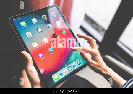 Bangkok, Thailand - Nov 22, 2018: Asian woman using the new 11 inch Apple iPad pro 2018, swiping home screen or touching app icon Stock Photo