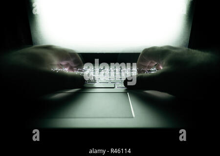 Hacker using laptop. Lots of digits on the computer screen. Stock Photo