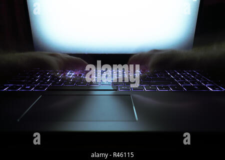 Hacker using laptop. Lots of digits on the computer screen. Stock Photo