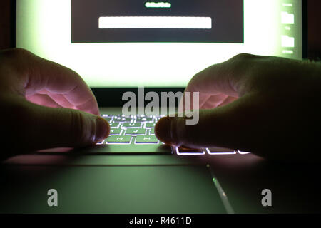 Hacker using laptop. Lots of digits on the computer screen. Stock Photo