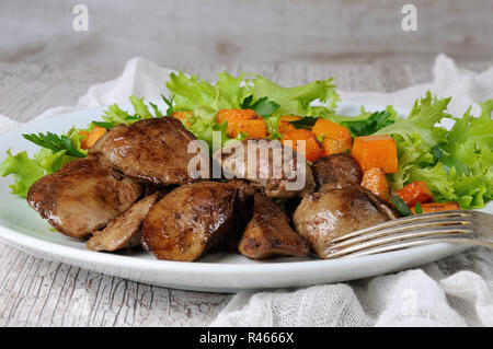 Chicken Liver with Vegetables. Fried chicken liver with vegetable garnish, baked pumpkin in lettuce leaves Stock Photo