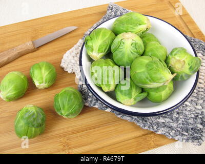 brussels sprouts in a bowl on a wooden board Stock Photo