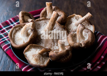 Shiitake Mushroom in Black Plate on Dark Wooden Surface. Organic Food. Stock Photo