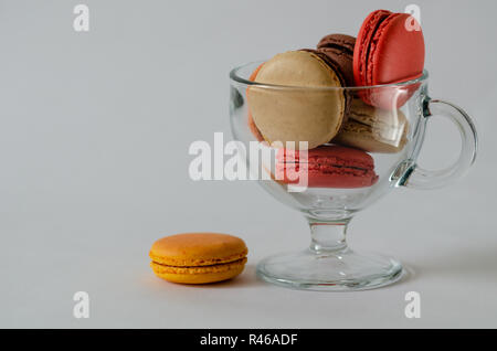 The cake in glass cup on the white  background is macaron or macaroon, soft pastel colors, copy space. Stock Photo