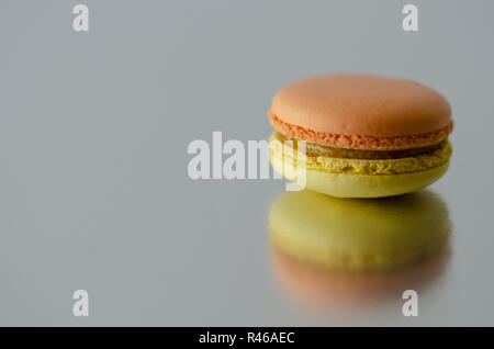 Two colored macarons are reflected on the table. Stock Photo
