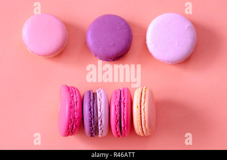 Colorful macaroons are on the pink background,top view. Stock Photo
