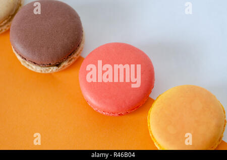 French macarons are on the orange-white background,top view. Stock Photo