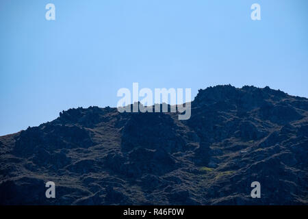 Distant mountain cores in mist in slovakia Tatra mountain trails in clear autumn day with blue sky and green vegetation Stock Photo