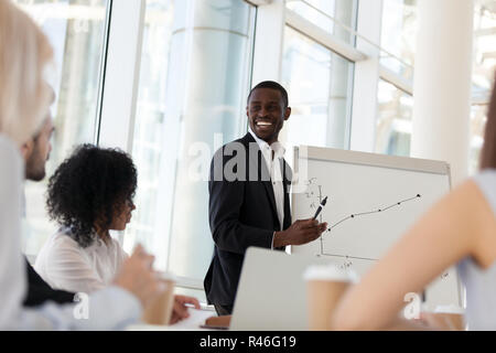 Smiling african mentor giving presentation at office training Stock Photo