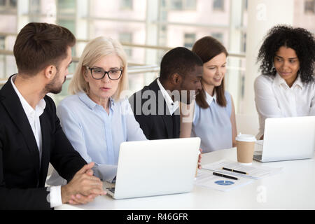 Serious focused diverse office employees group talking working o Stock Photo