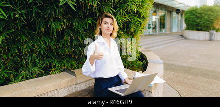 Successfiul businesswoman working with laptop and papers in open Stock Photo