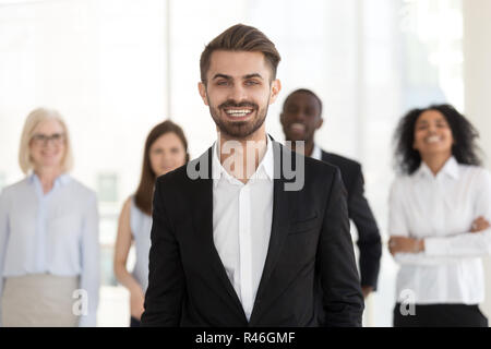 Smiling young businessman looking at camera posing with diverse  Stock Photo