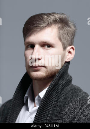 close up.a stylish young man in a cardigan.isolated on grey background Stock Photo