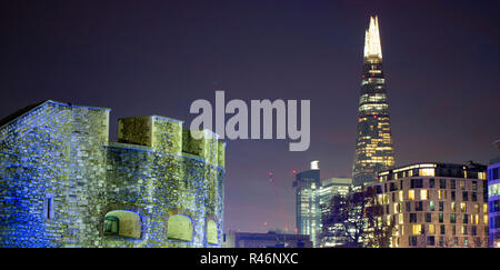 London, England November 26 2016. A shot of the skyscraper lit up at night with the tower of London in the foreground Stock Photo