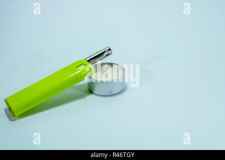 Candle and a green lighter on white isolated background Stock Photo