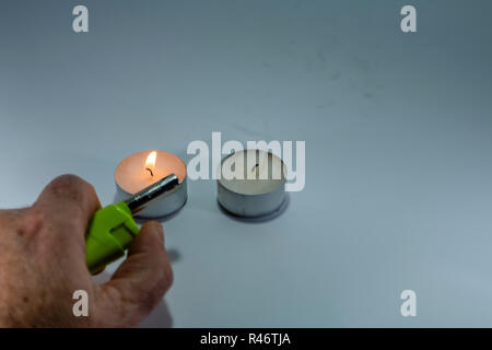 Candle  and green lighter with hand on white background isolated Stock Photo