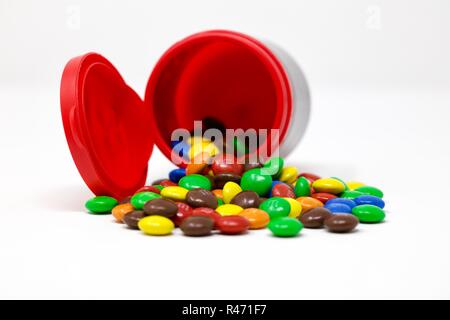 An Open Container Of M&M Minis (chocolate Button Shaped Candies) Spilling  Out And Scattered Across A White Backdrop. Over 100 Minis In Each Tube.  Made By Mars Inc. Editorial Use Only Stock