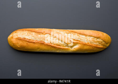 Top view of a crusty baguette peeking out from a brown paper bag ...