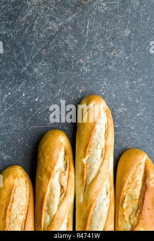 Top view of a crusty baguette peeking out from a brown paper bag ...