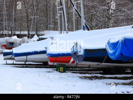 Perspective of sailing ships on shore with snow Stock Photo