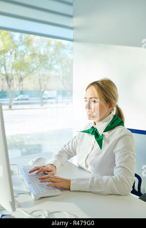 Busy lady in corporate outfit working with computer Stock Photo