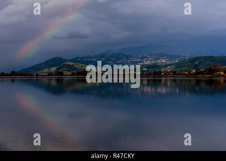 The rainbow is reflected in the waters of Lake Massaciuccoli, Lucca, Tuscany, Italy Stock Photo